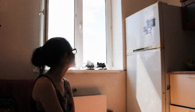 冷蔵庫を見つめる女性