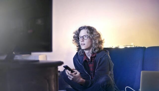 テレビ画面でアニメを視聴する男性