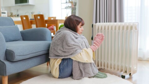 ストーブで暖める女性